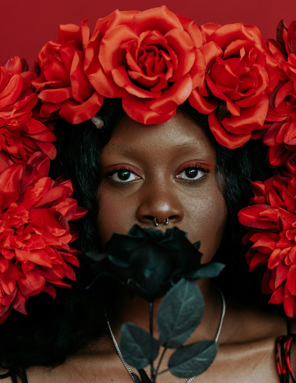 Frau mit roter Rose auf dem Mund
