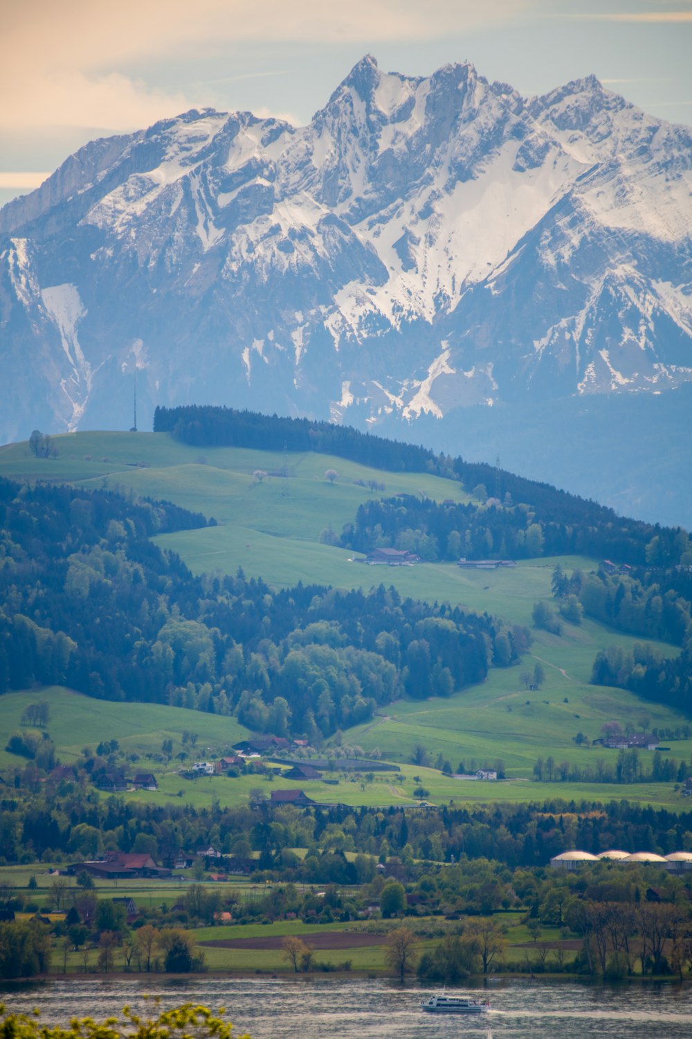 green grass field near snow covered mountain during daytime