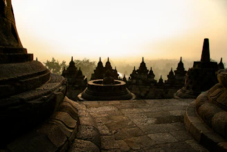A tranquil meditation session at sunrise with a backdrop of ancient Indian temples.