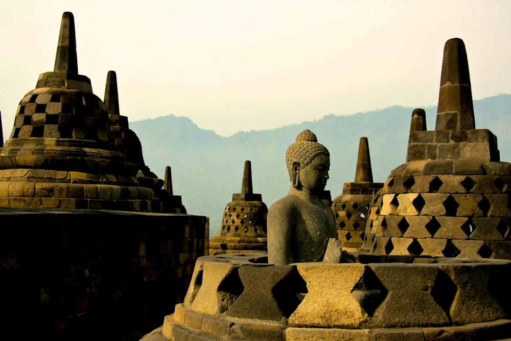 gold buddha statue on top of white and brown concrete building during daytime