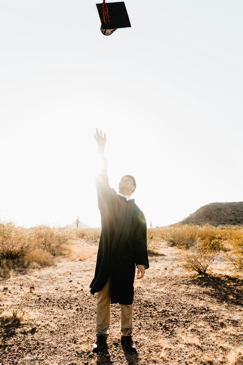 man in black suit standing on brown field during daytime