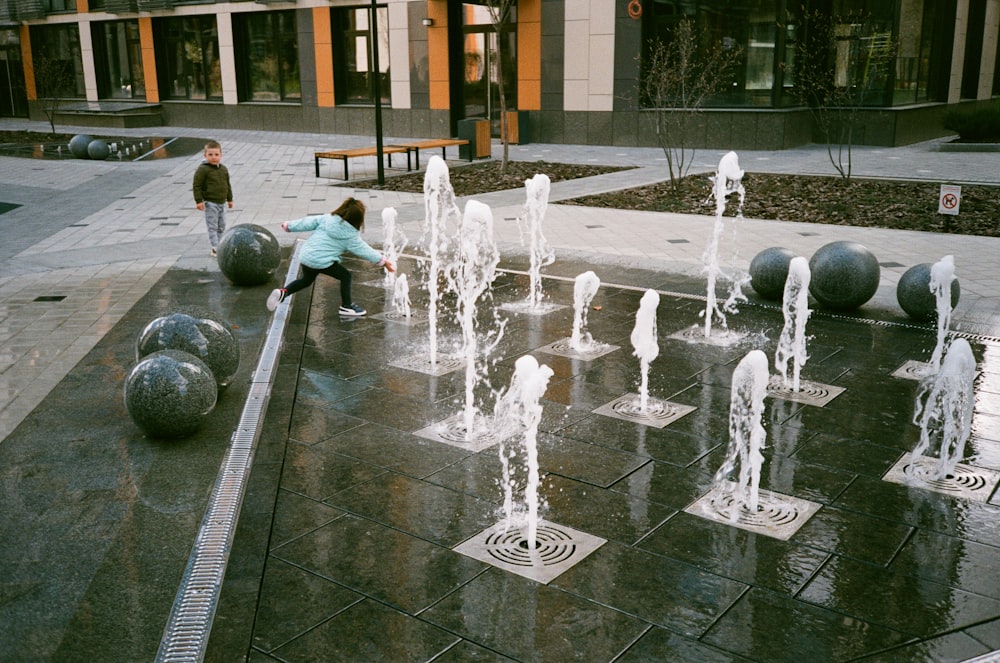persone che giocano sulla fontana d'acqua durante il giorno