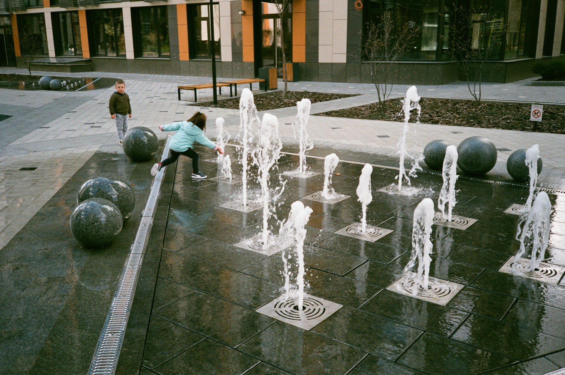 people playing on water fountain during daytime