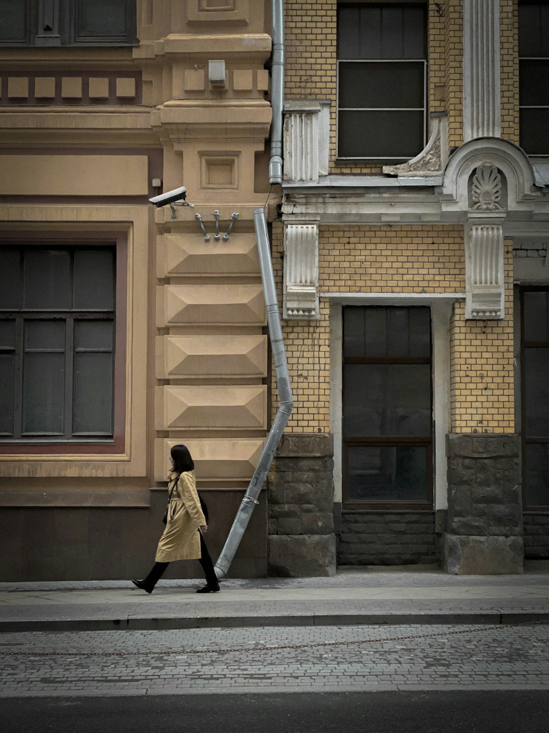 woman in black coat walking on sidewalk during daytime