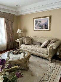 Close-up of a beautifully designed living room with maroon accents and beige furnishings.