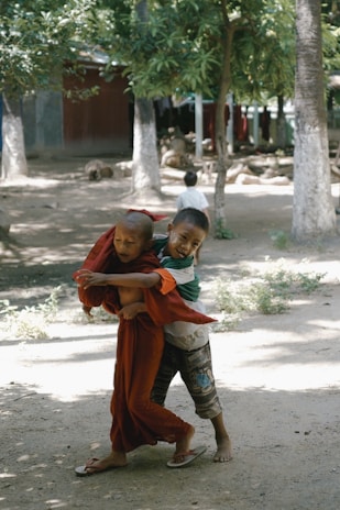 Kids engaged in a playful outdoor activity under the shade of trees.