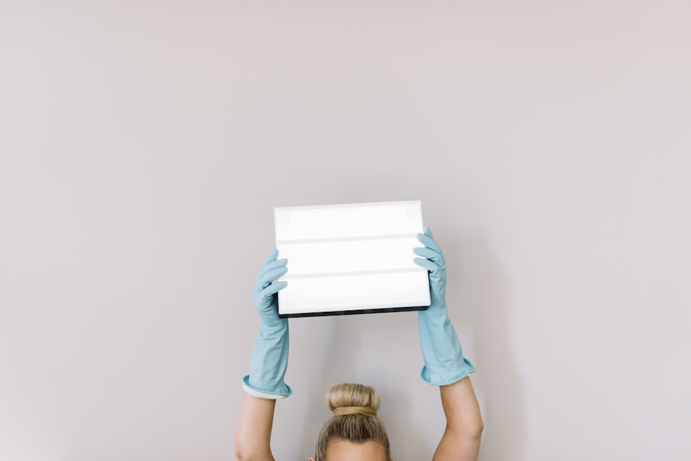 menina na camiseta azul-petróleo segurando o papel branco