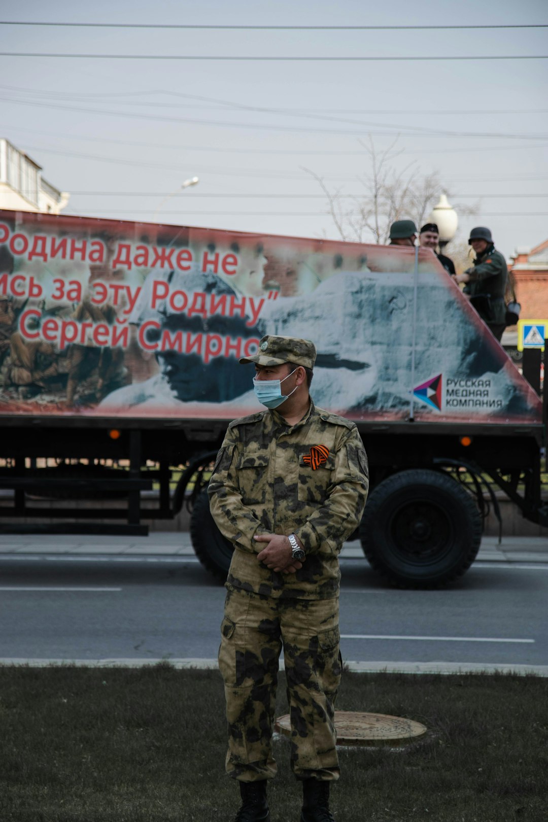 man in green and brown camouflage uniform standing near black truck during daytime