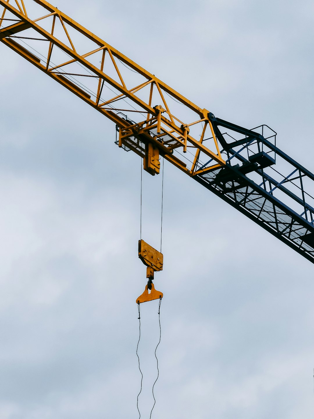 yellow crane under cloudy sky during daytime