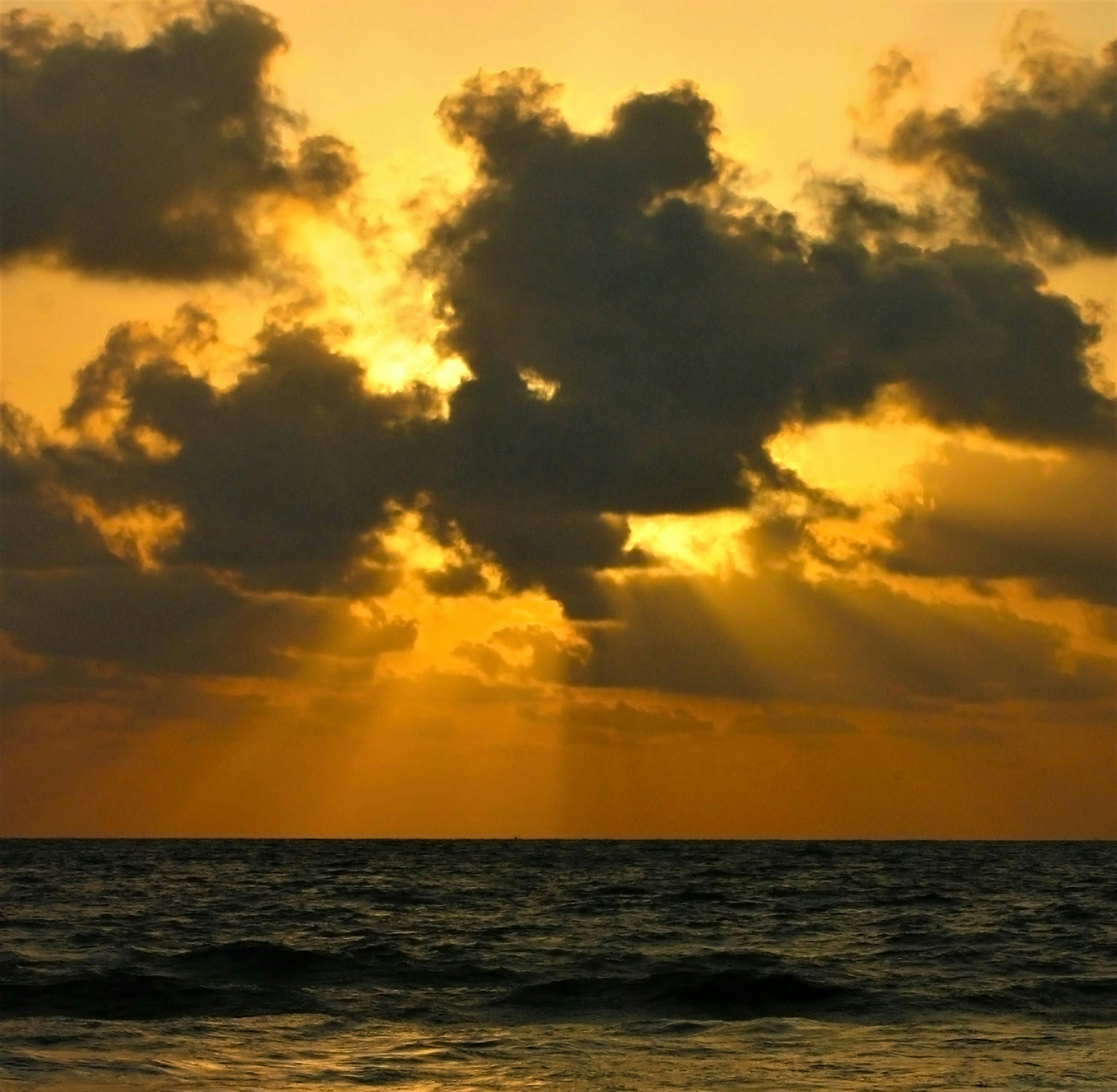 body of water under cloudy sky during sunset