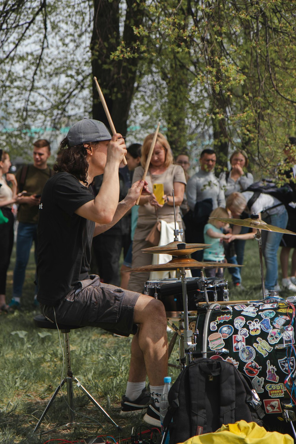 man in black t-shirt playing drum during daytime