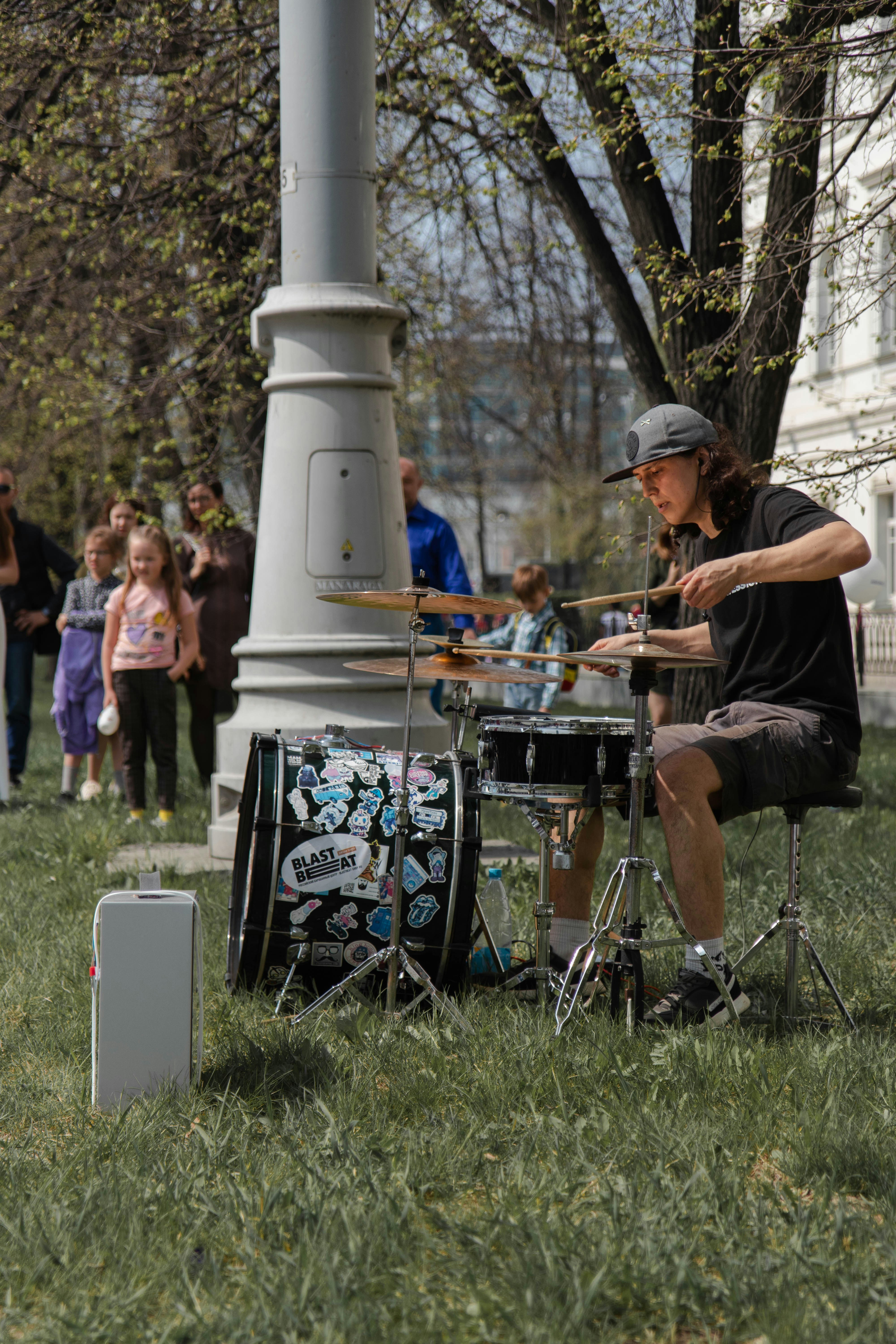 man in black t-shirt playing guitar on green grass field during daytime
