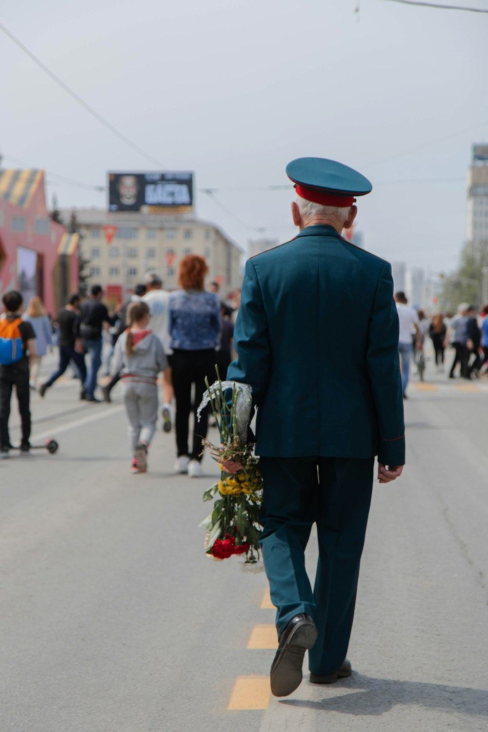 homme en costume noir marchant dans la rue pendant la journée