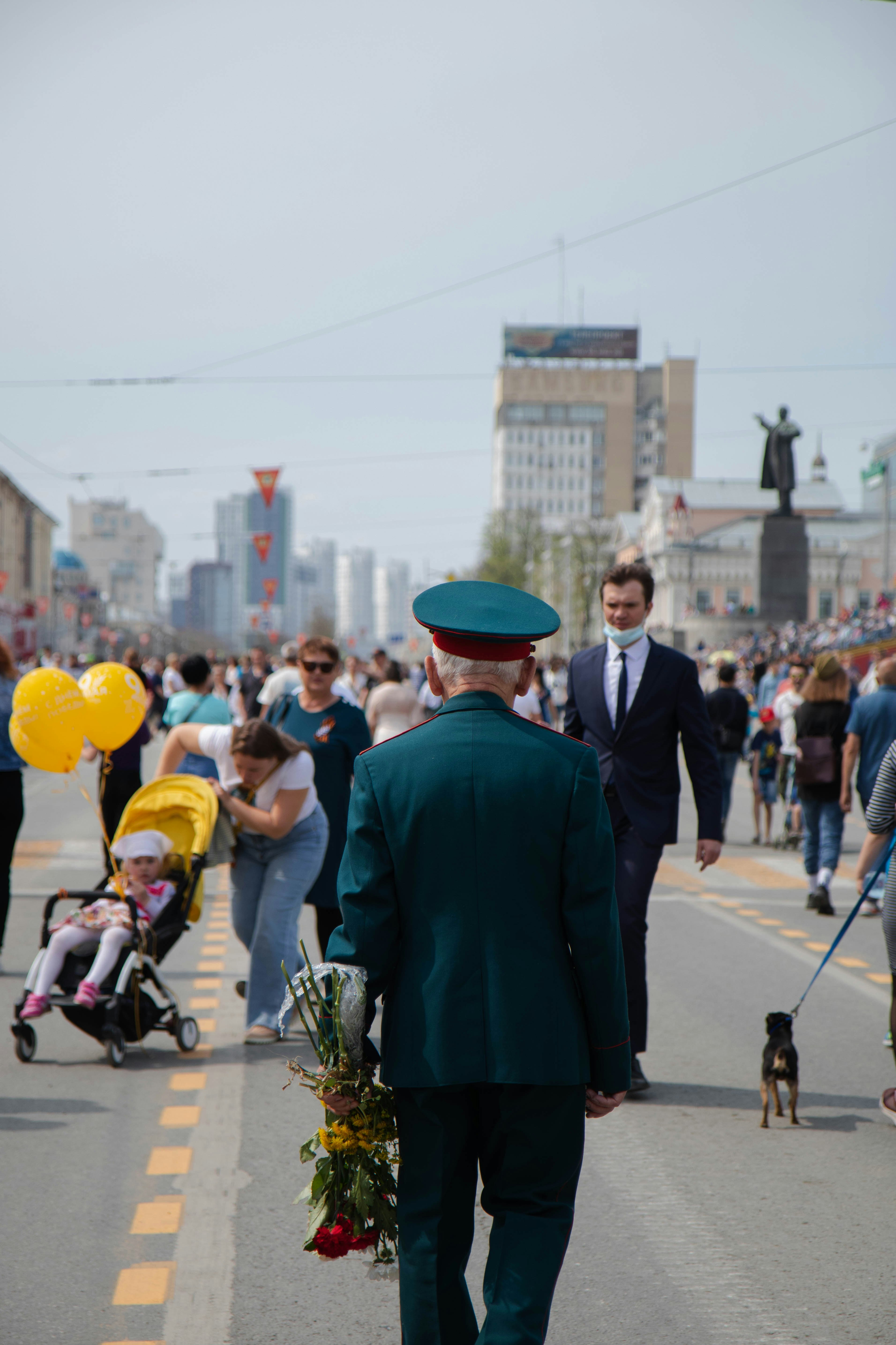 man in green suit walking on street during daytime