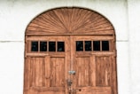 brown wooden door on white concrete wall