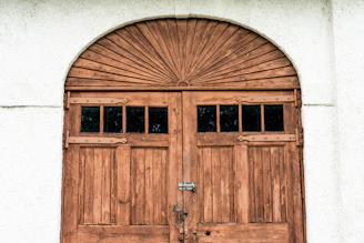 brown wooden door on white concrete wall