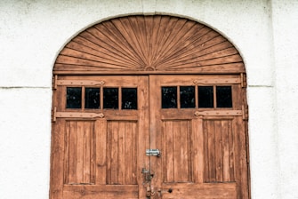brown wooden door on white concrete wall