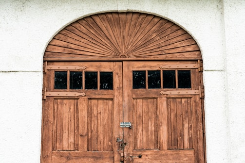 brown wooden door on white concrete wall
