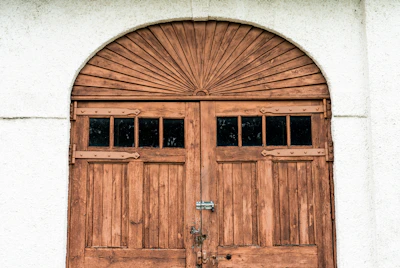 brown wooden door on white concrete wall