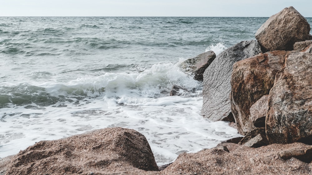 brown rock formation near body of water during daytime