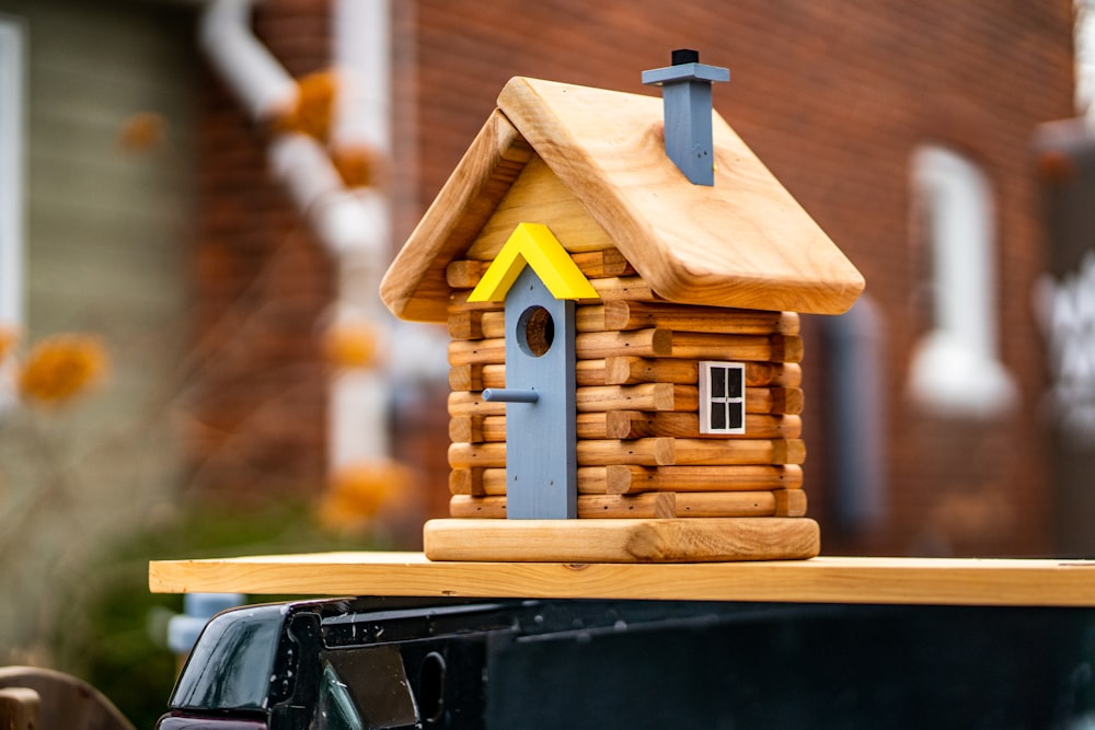 Miniatura de la casa de madera marrón en el coche negro