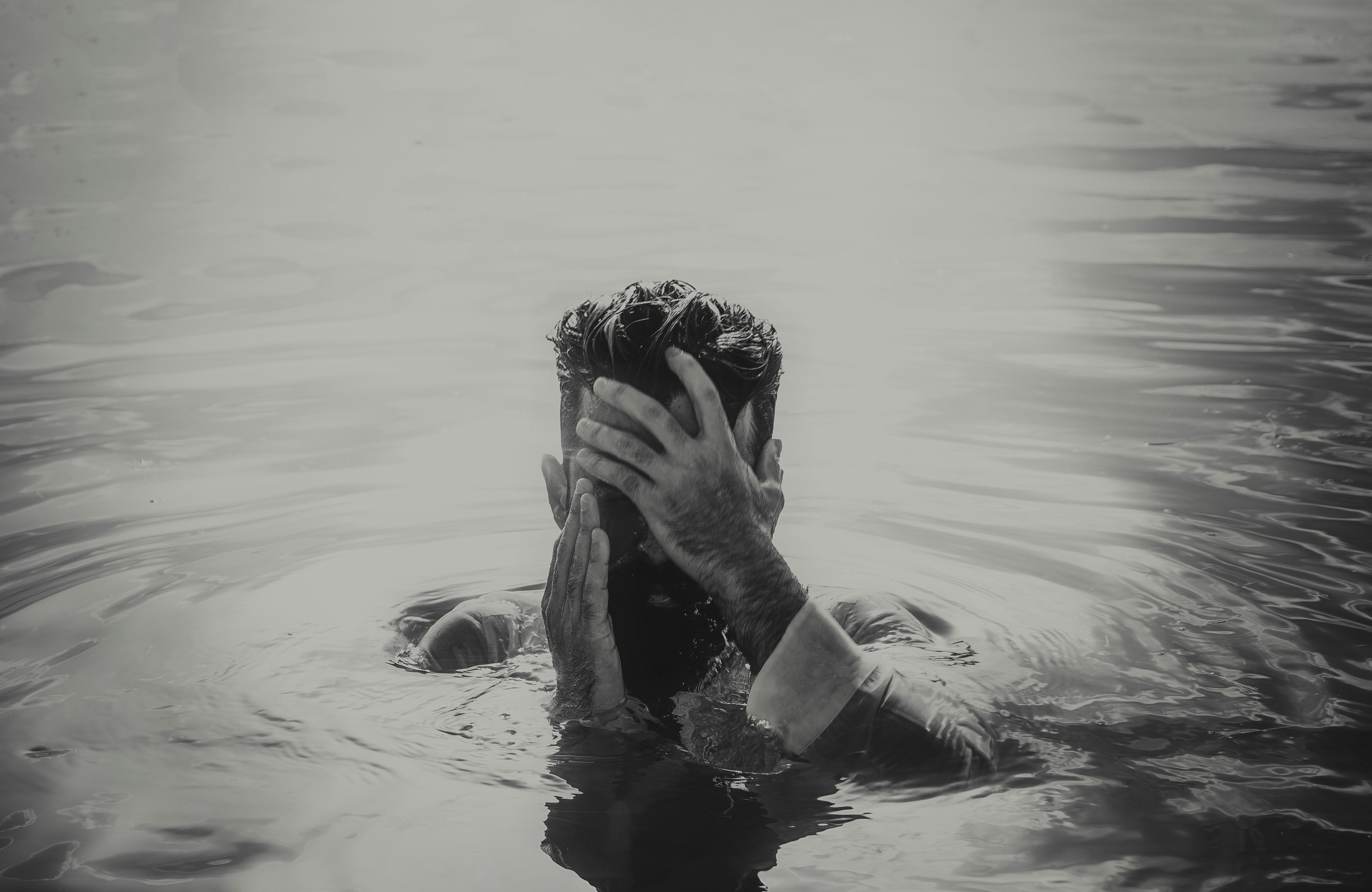 woman in water covering her face
