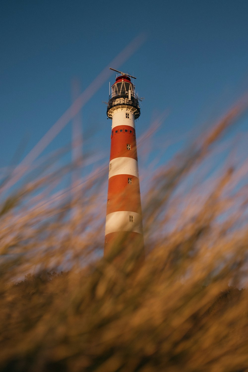 white and red lighthouse under blue sky during daytime