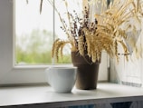 A ceramic mug adorned with artisan brush strokes, placed near a window with soft natural light.