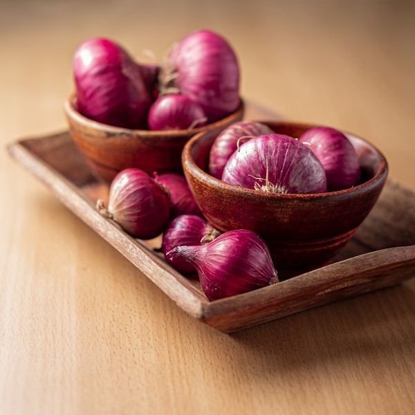 Red onion on brown wooden tray