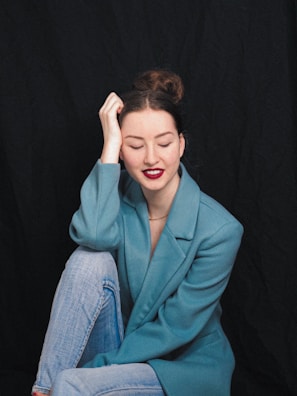 A professional woman seated at her desk, eyes closed, practicing a 15-minute meditation during lunch break.