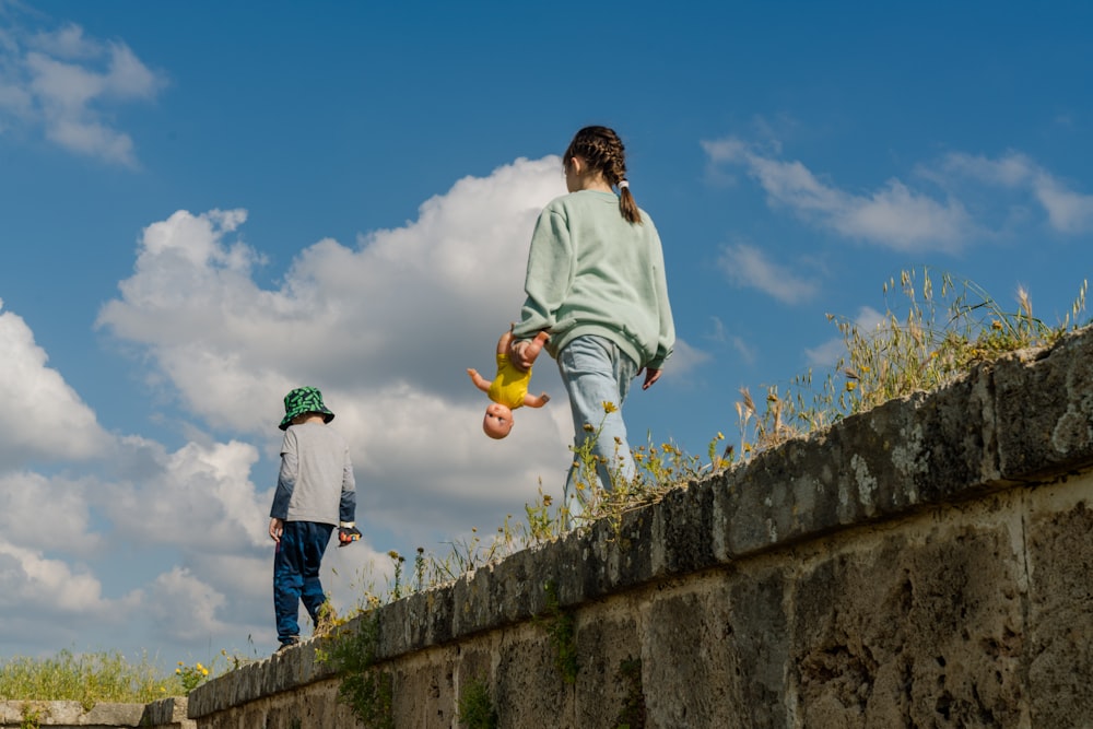 man in white shirt and blue denim jeans holding yellow ball