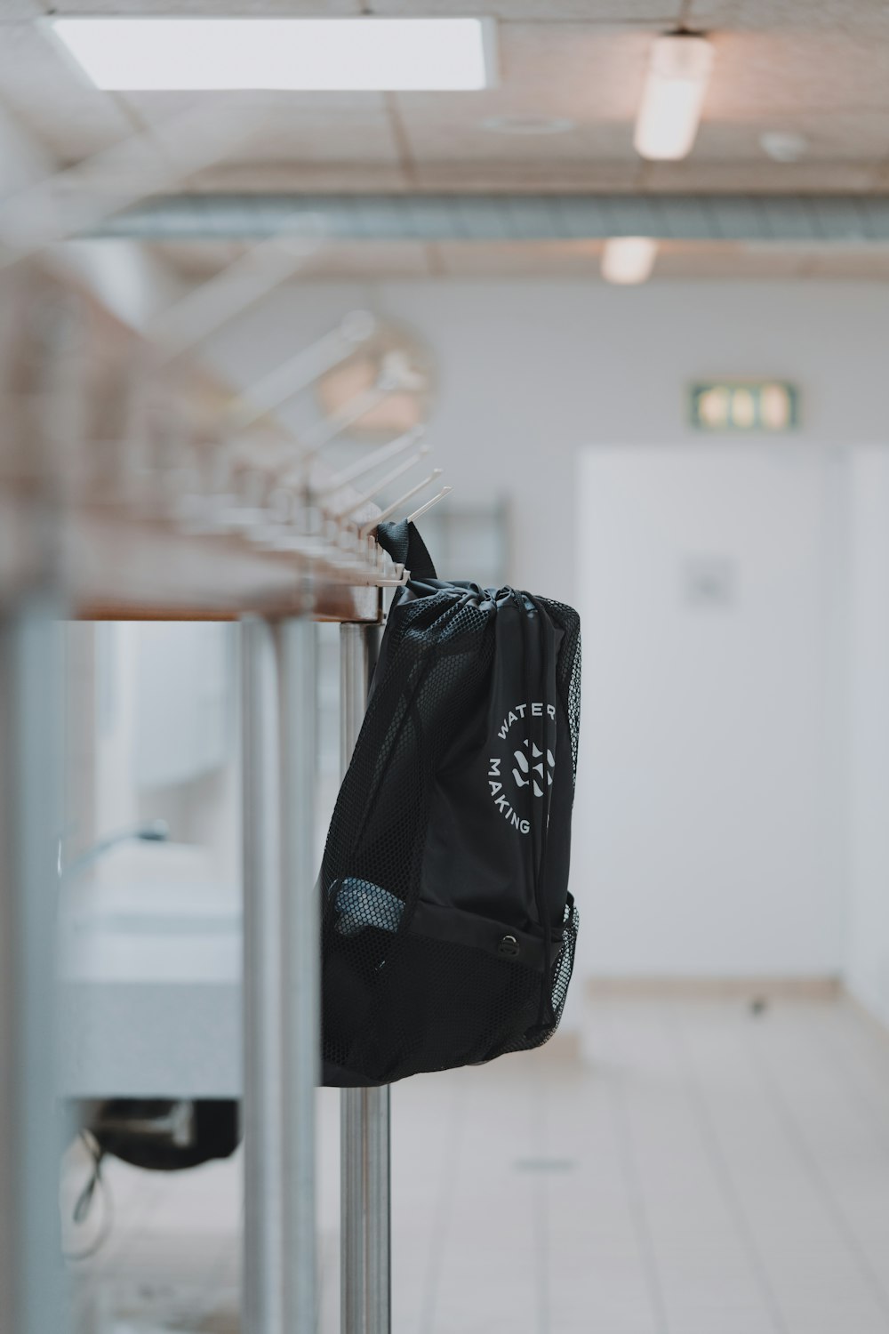 black and white nike backpack hanged on white wall