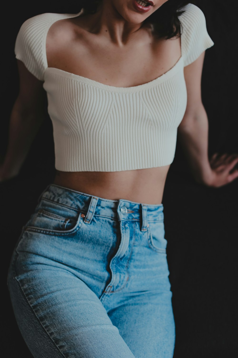 woman in white tank top and blue denim jeans