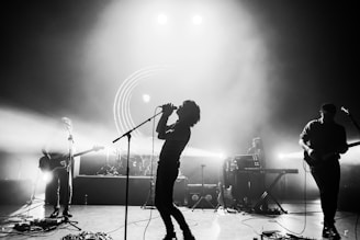 man singing on stage in front of people