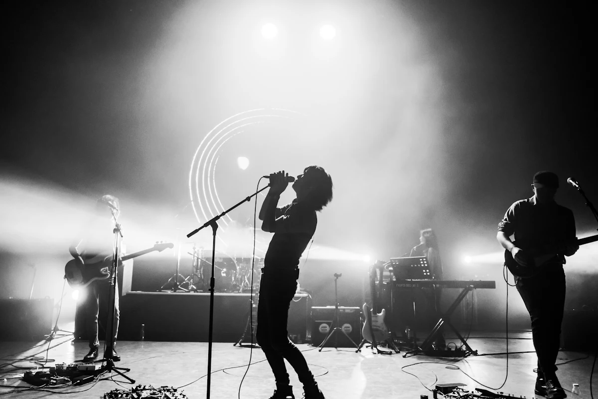 A singer at the microphone, lit from behind by the stage lights