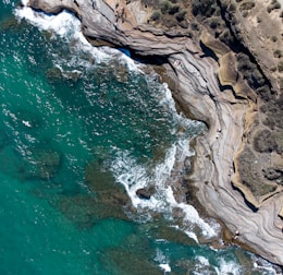 brown rock formation beside body of water during daytime