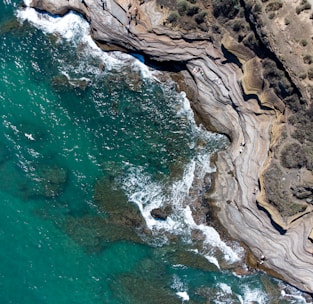brown rock formation beside body of water during daytime