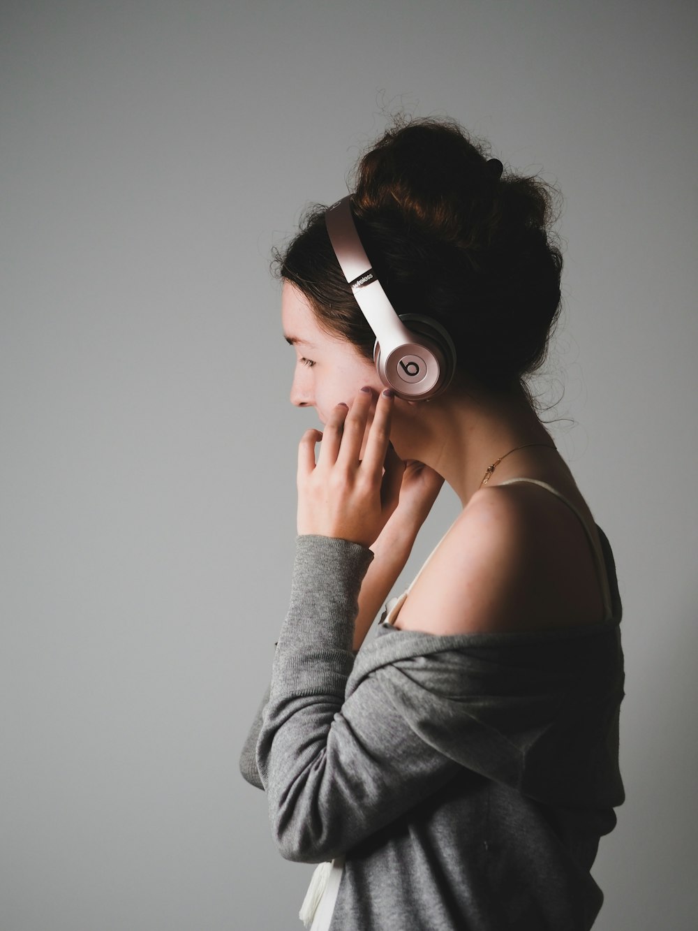 woman in gray long sleeve shirt wearing white headphones