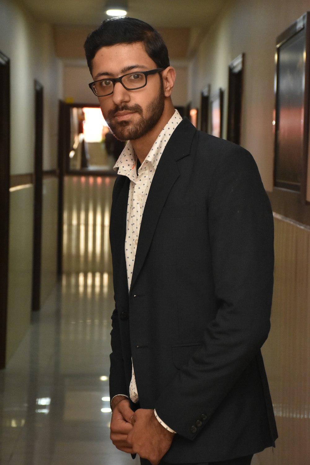 man in black suit jacket wearing eyeglasses