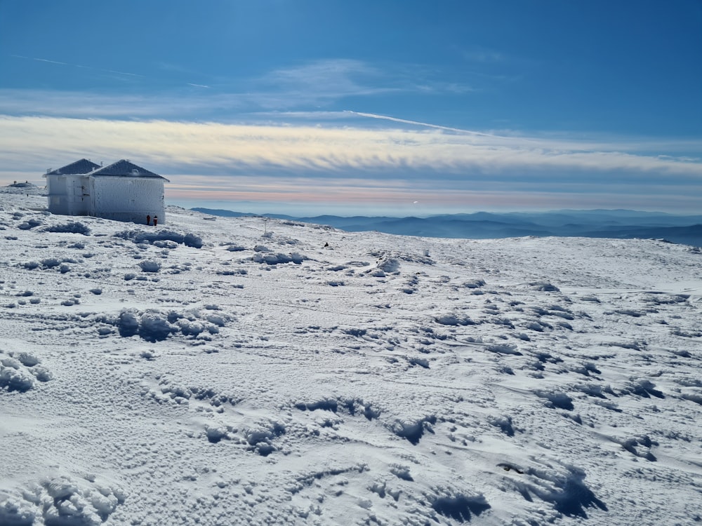 weiß-graues Haus auf schneebedecktem Boden unter blauem Himmel tagsüber