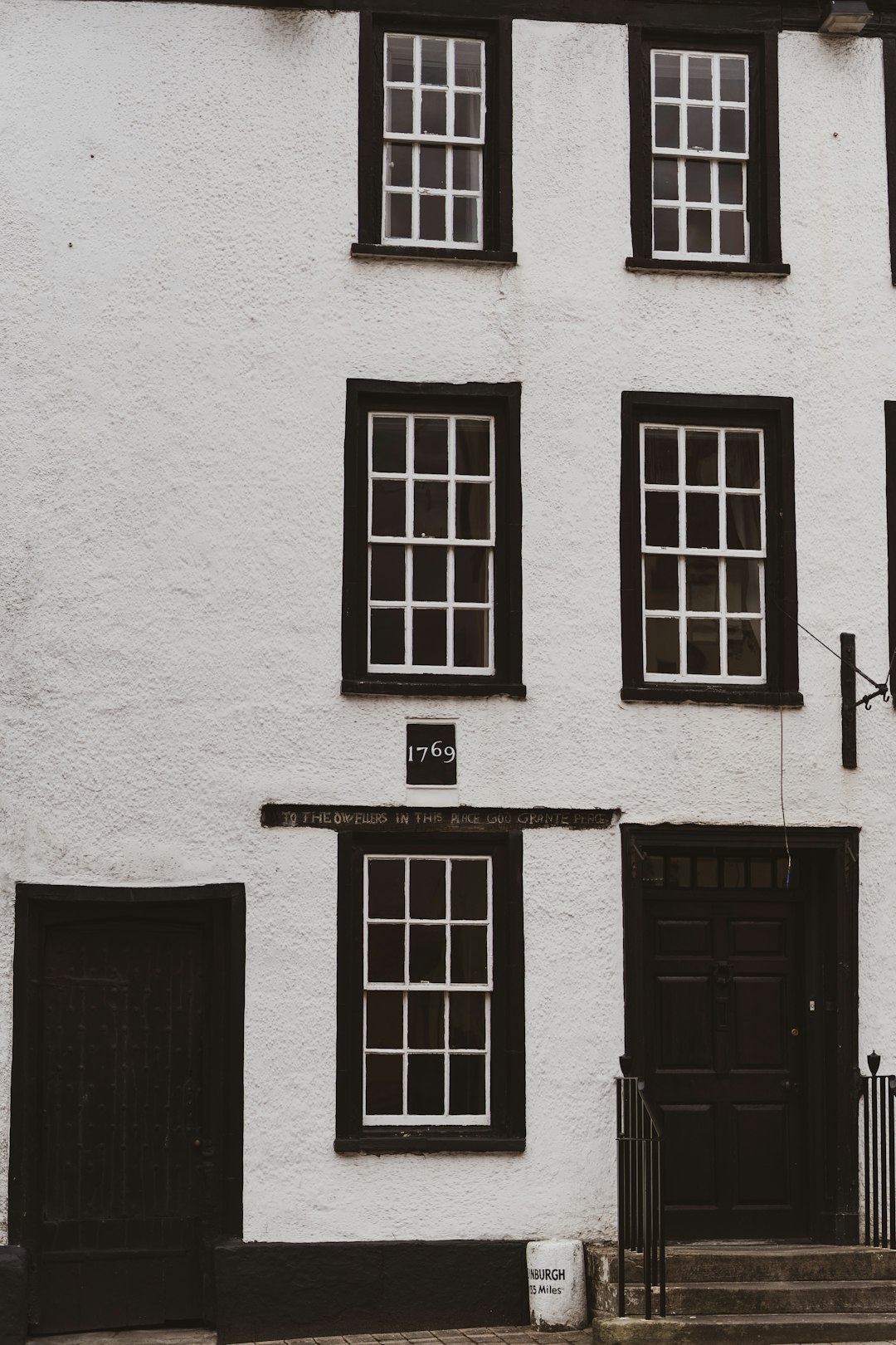 black wooden door on white concrete building