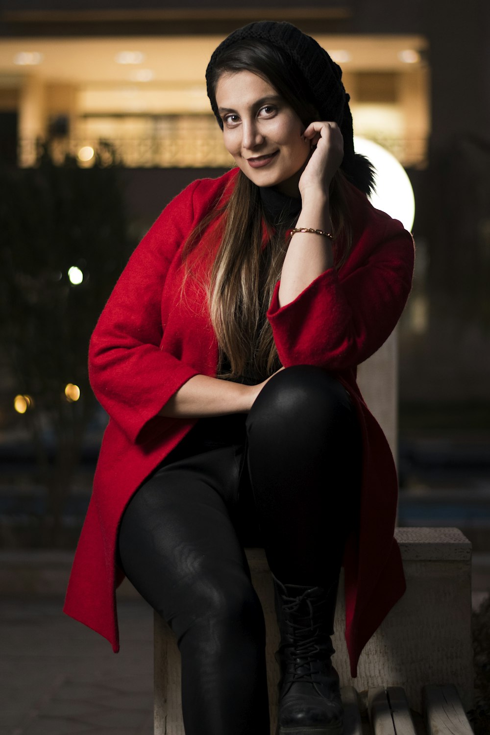 woman in red hoodie and black leggings sitting on brown wooden bench
