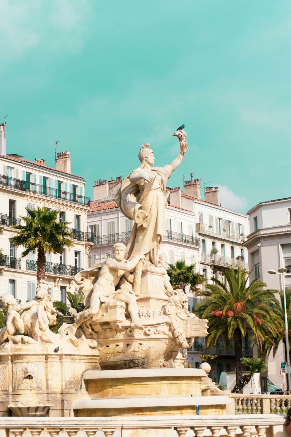 Estatua de hormigón blanco cerca de un edificio de hormigón blanco durante el día