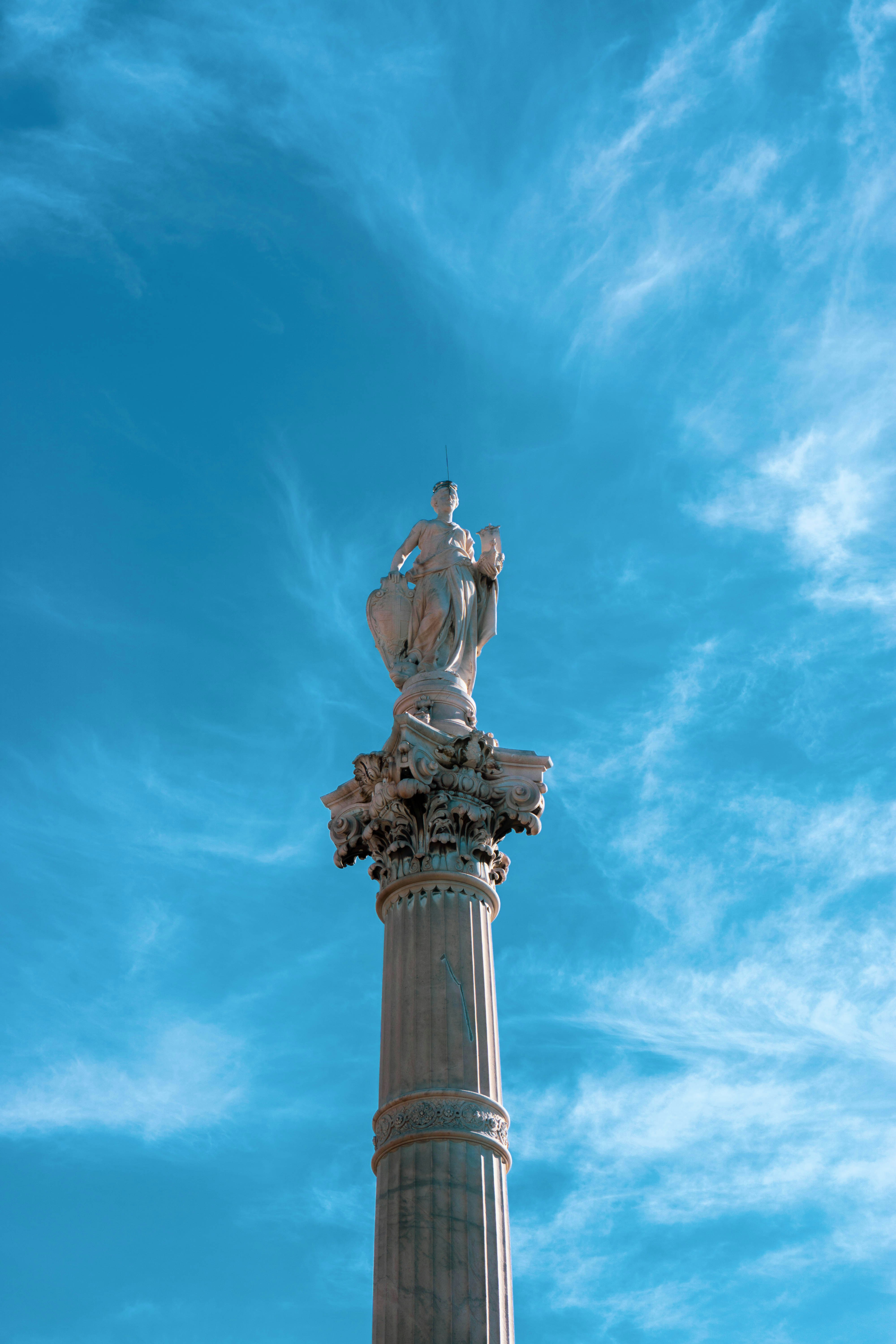 man in black suit statue under blue sky during daytime