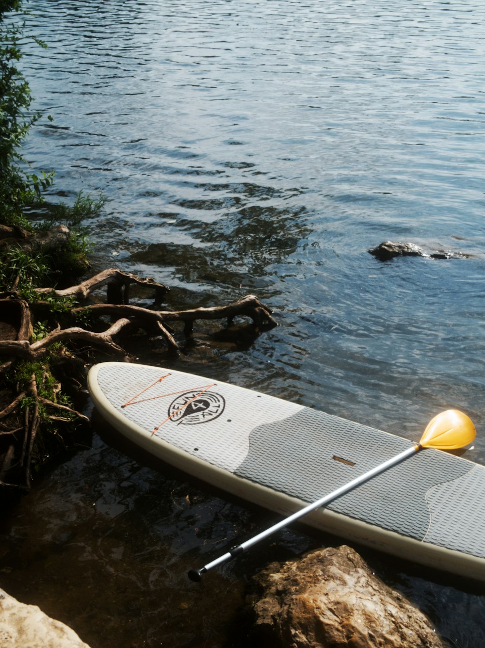 white and brown surfboard on body of water during daytime