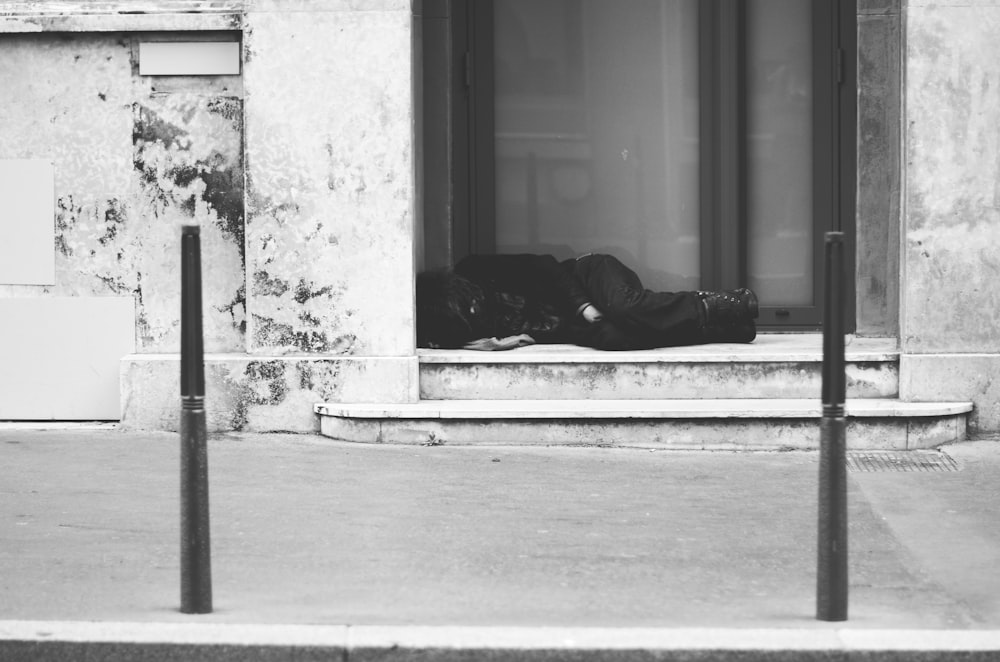 grayscale photo of man lying on floor