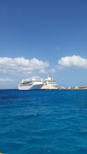 A joyful family boarding a cruise ship under a bright blue sky, ready for their vacation.