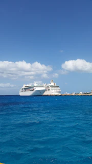 A vibrant photo of a family happily boarding a cruise ship under clear blue skies.