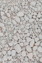 Sand being evenly distributed on top of the stone layer for stability.