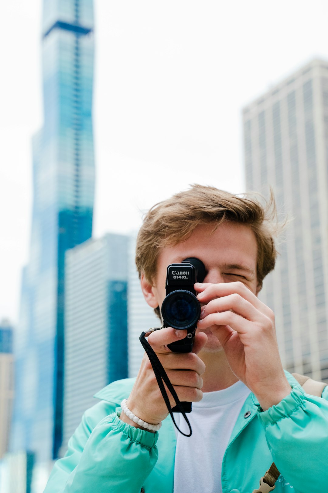 woman in teal shirt holding black camera